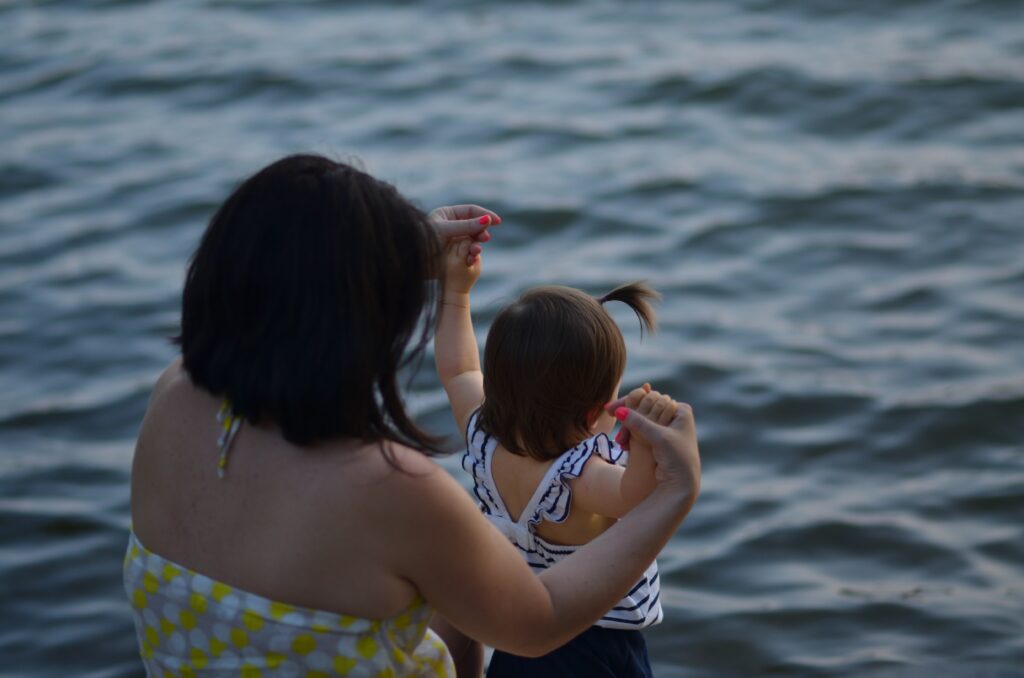 Illustrative photo woman with child by the lake